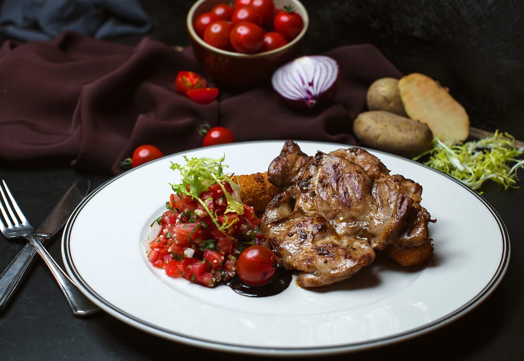 fried meat with chopped tomato salad